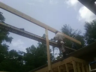 Carpenter setting a ridge beam over a new addition frame — Ice Dam Removal by Roofing Brothers in Montoursville