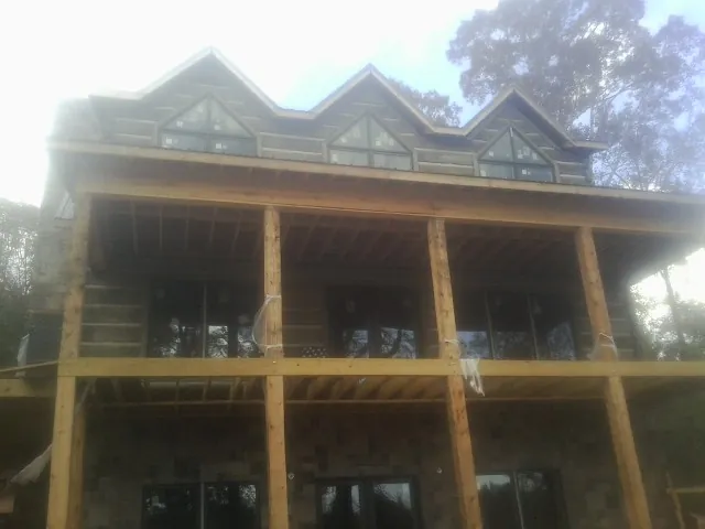 Dormers and porch framing on a large log home under construction — Roof Coating work by our crew in Montoursville