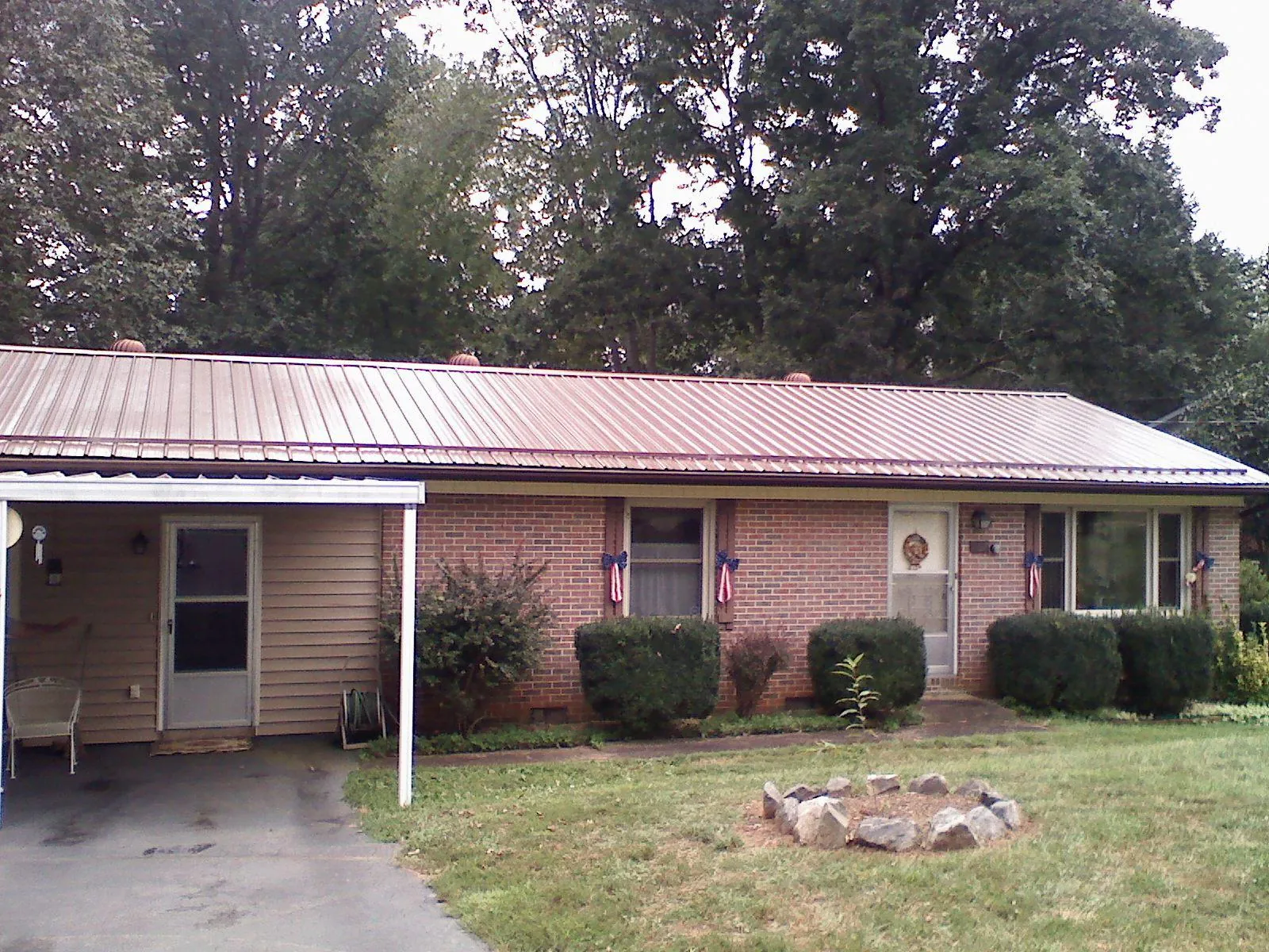 Bronze metal roof and carport on a brick ranch home — Roof Repair work by our crew in Montoursville